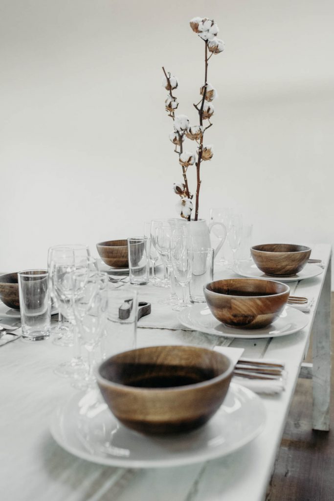 A clean, modern wedding breakfast tablescape of neutral tones and wooden accents