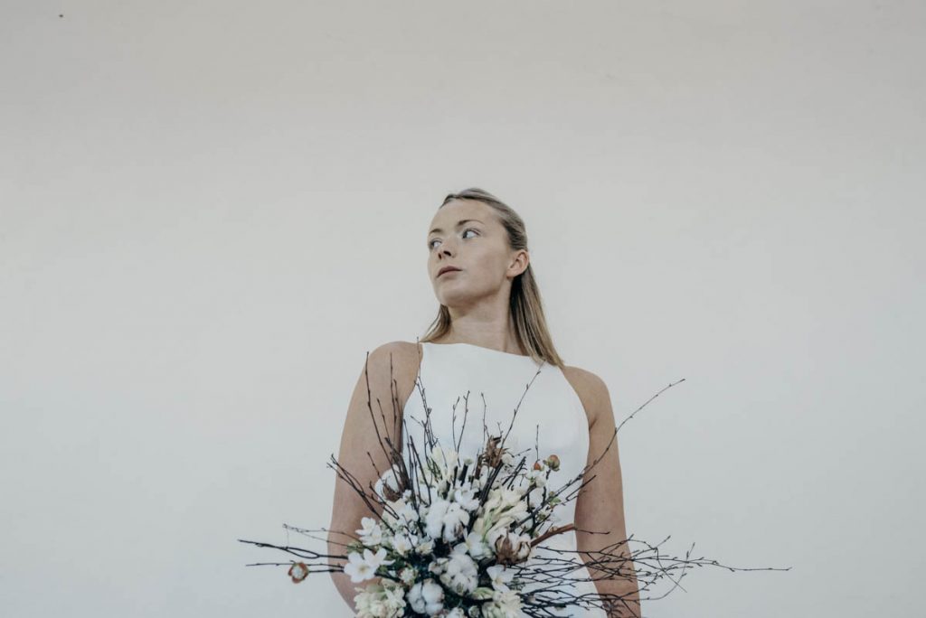 A modern bride in a sleek sophisticated sleeveless wedding gown