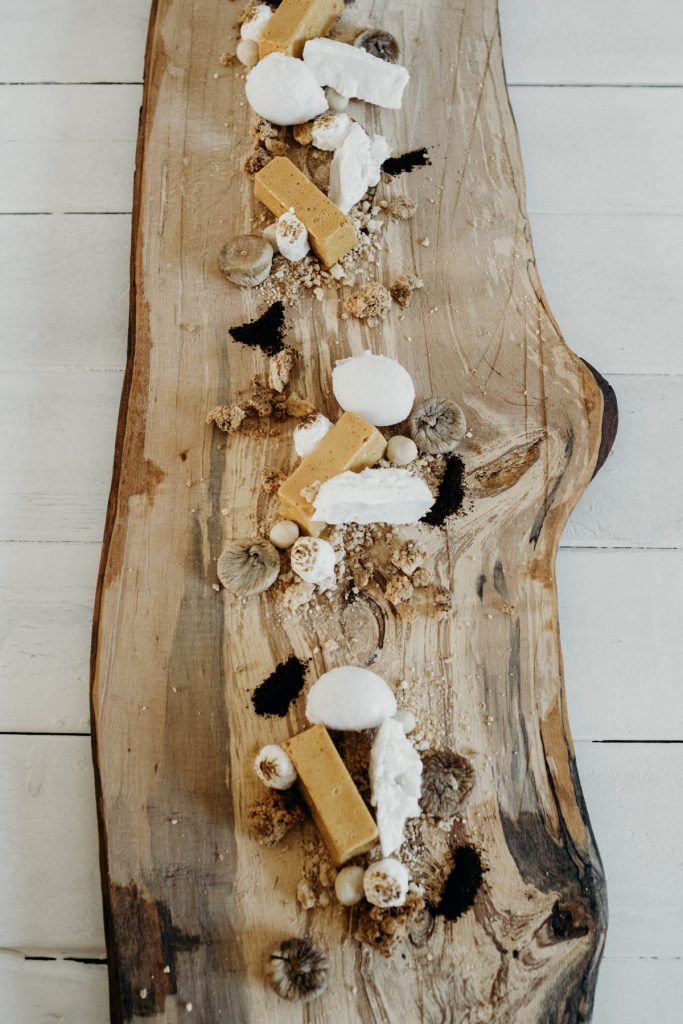 A fish board of sprats, cod skin, salted cod, scallops, squid + pickled mackerel for modern barn wedding
