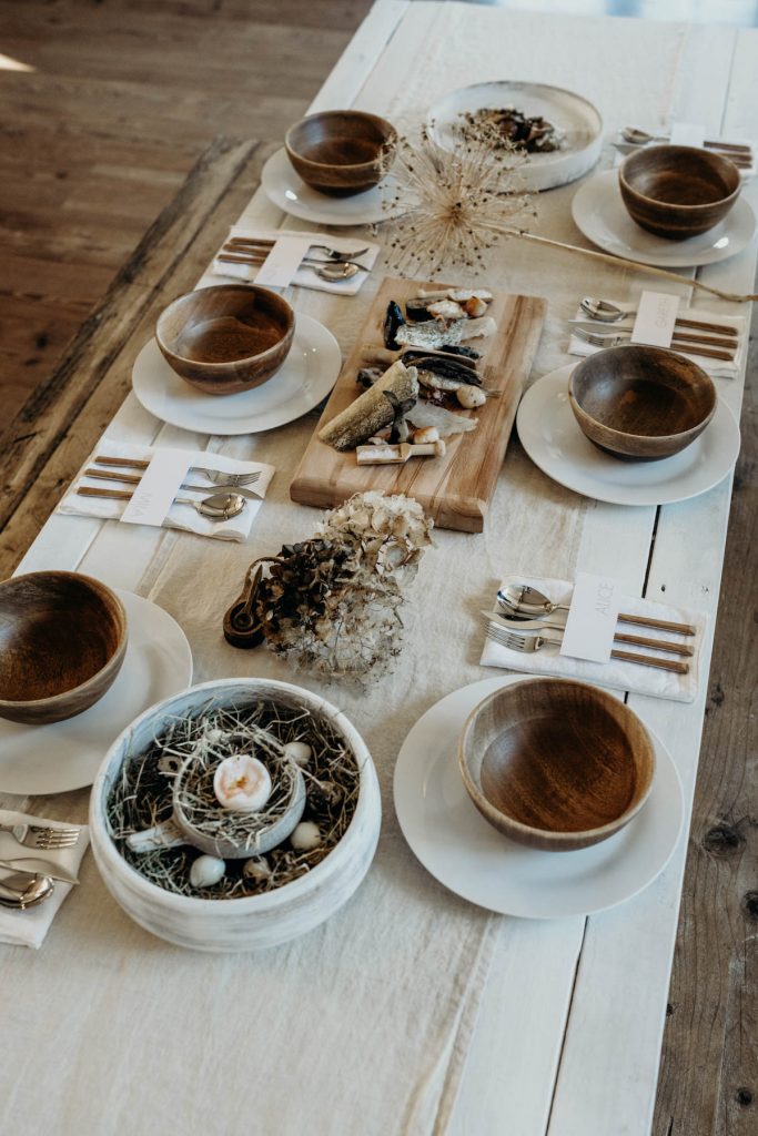 A clean, modern wedding breakfast tablescape of neutral tones and wooden accents