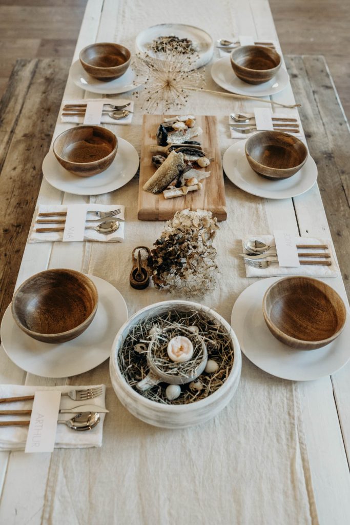 A clean, modern wedding breakfast tablescape of neutral tones and wooden accents