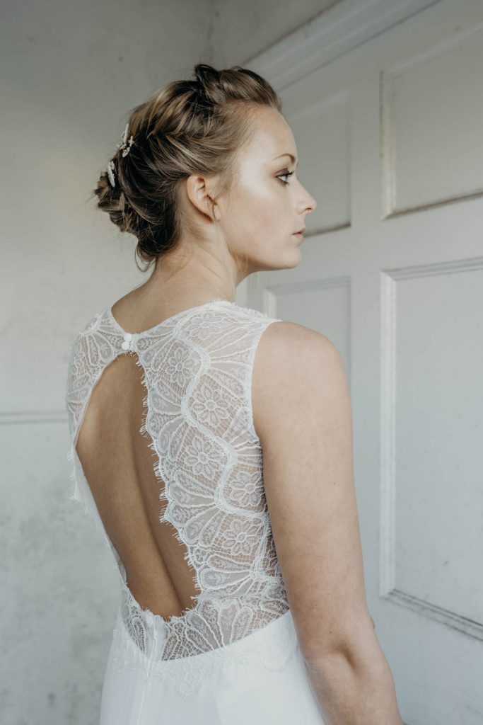 A modern bride with an intricately detailed keyhole back wedding dress and up do