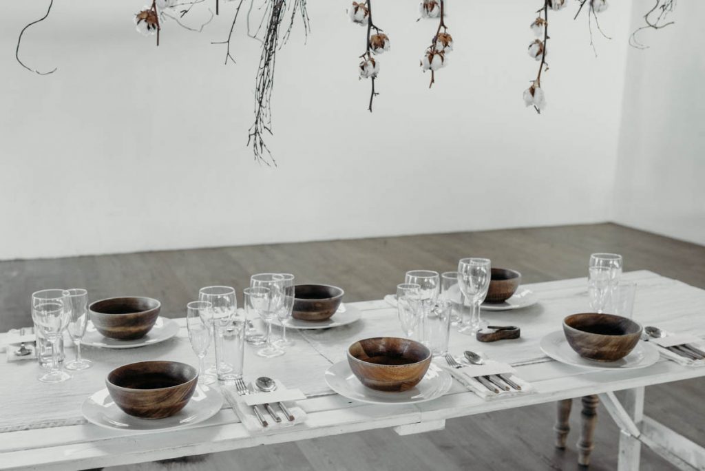 A clean, modern wedding breakfast tablescape of neutral tones and wooden accents