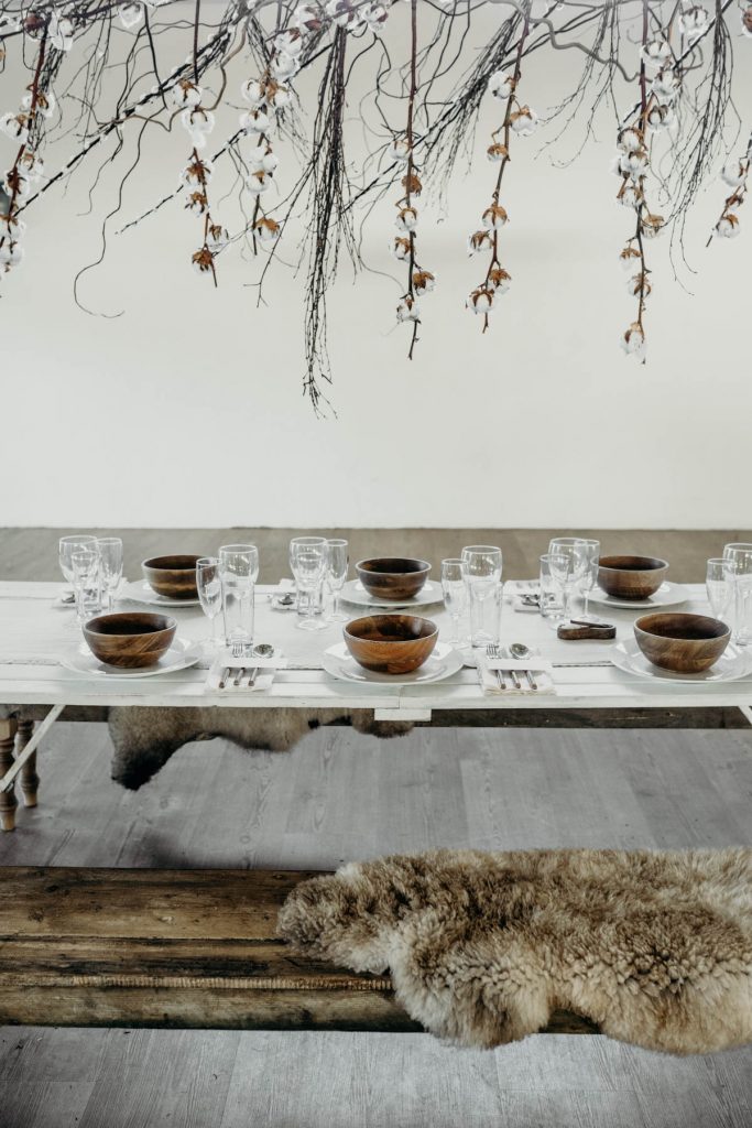 A clean, modern wedding breakfast tablescape of neutral tones and wooden accents