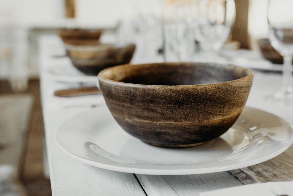 A clean, modern wedding breakfast tablescape of neutral tones and wooden accents