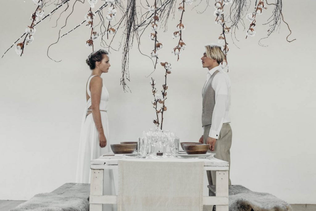 A clean, modern wedding breakfast tablescape of neutral tones and wooden accents