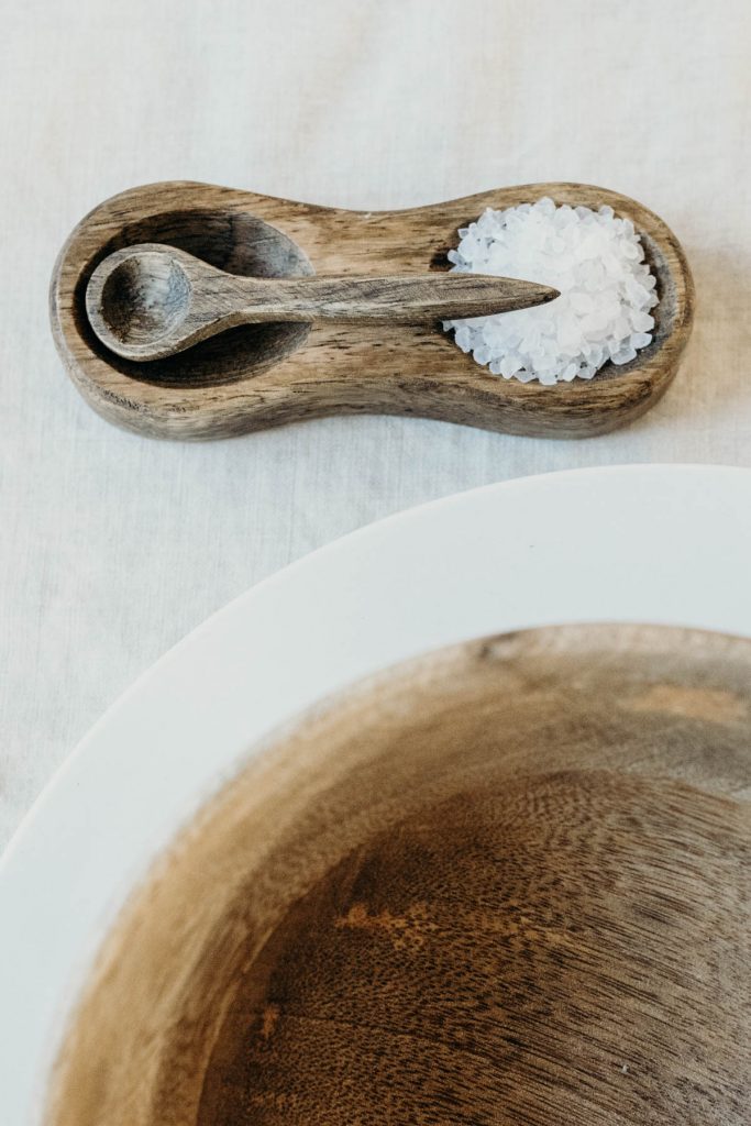 A clean, modern wedding breakfast tablescape of neutral tones and wooden accents