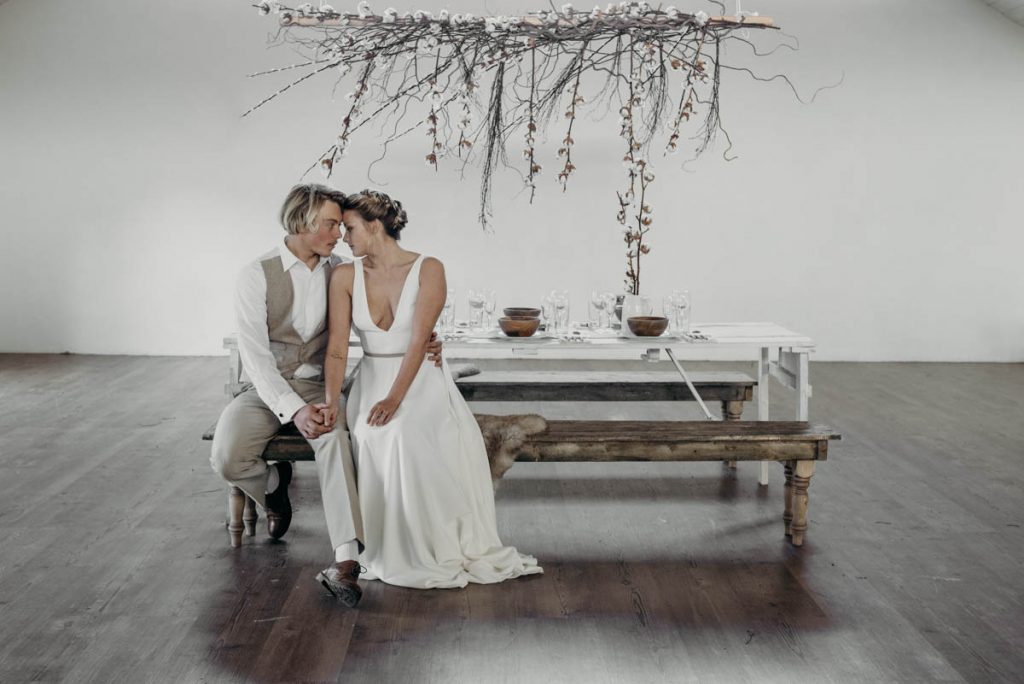 A clean, modern wedding breakfast tablescape of neutral tones and wooden accents
