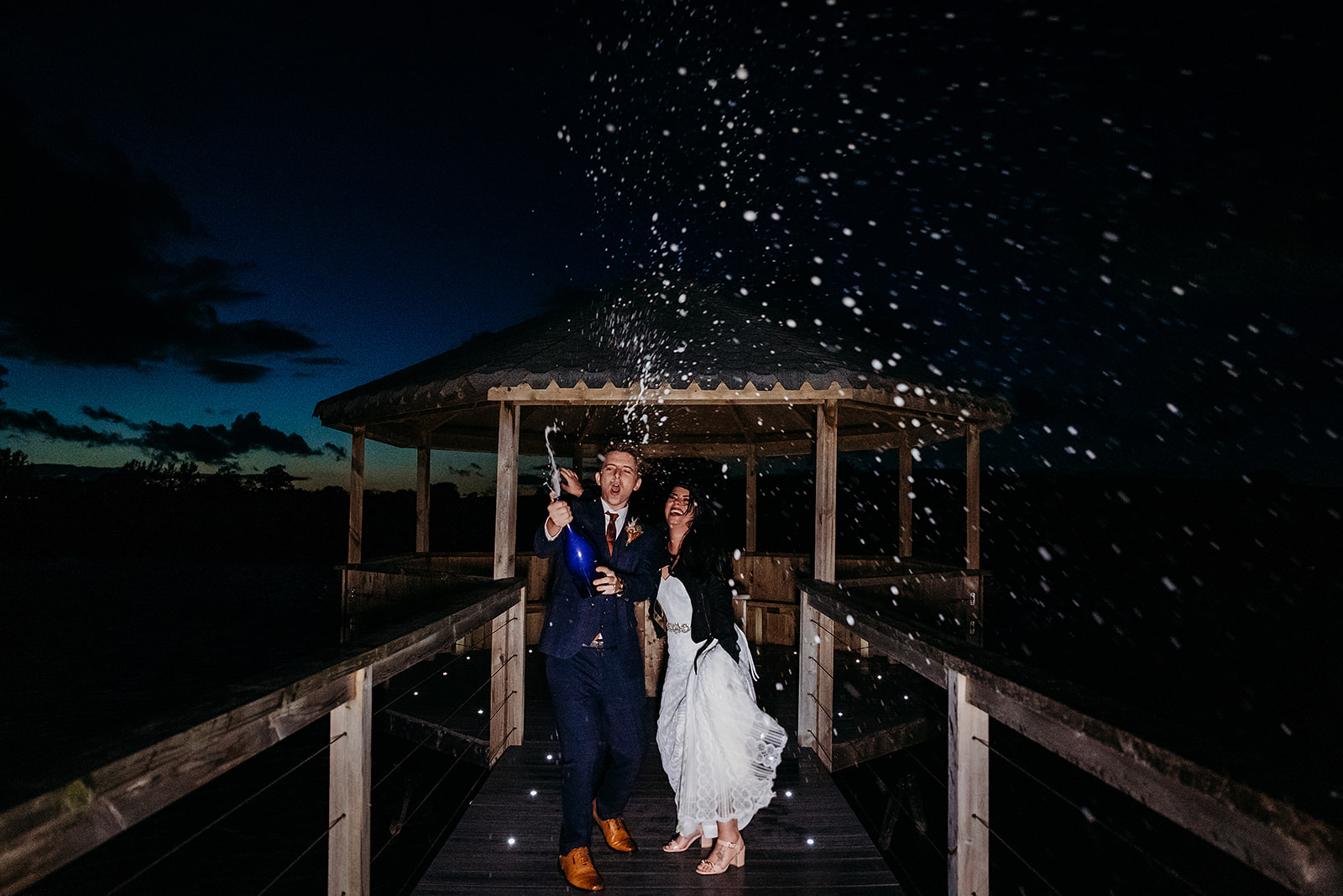Champagne shot at dusk for newly married bride and groom at Quantock Lakes