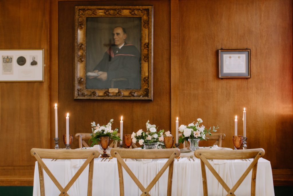 A winter wedding table with cream linen textured cloths and a colour palette of ambers, greens and a hint of gold