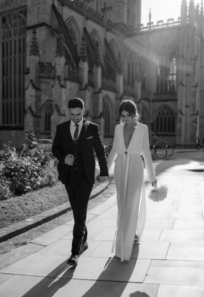 A newly married couple walk the streets of Bath, following their city registry office service