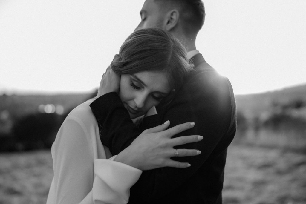 A newly wed couple gently embrace one another during a sunset portrait session on the evening of their city elopement