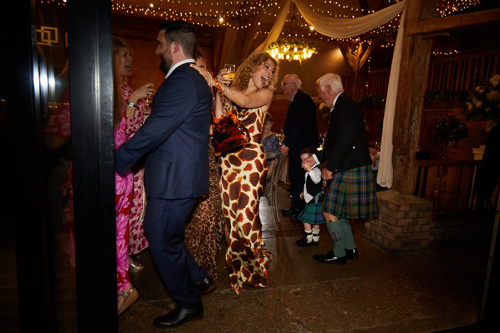 Guests at Lains Barn wedding venue form a conga line and dance around the barn
