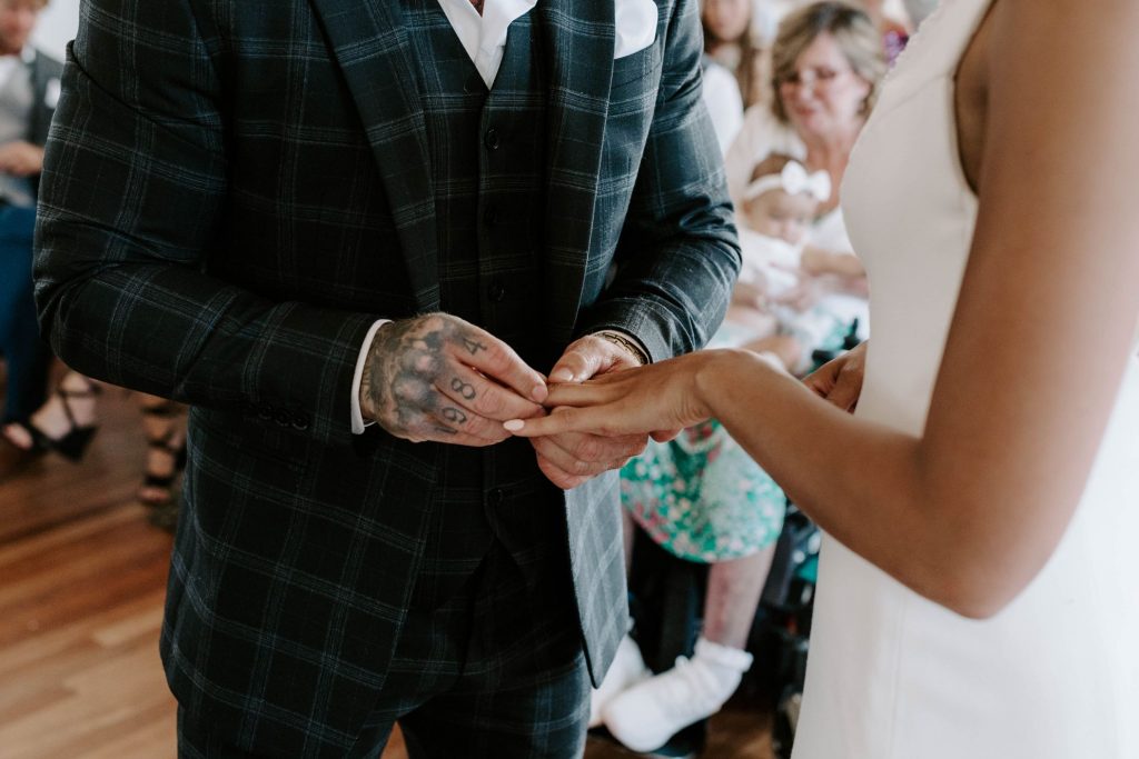 A groom puts a ring on his soon to be bride's finger during their wedding ceremony in Poole Registry office
