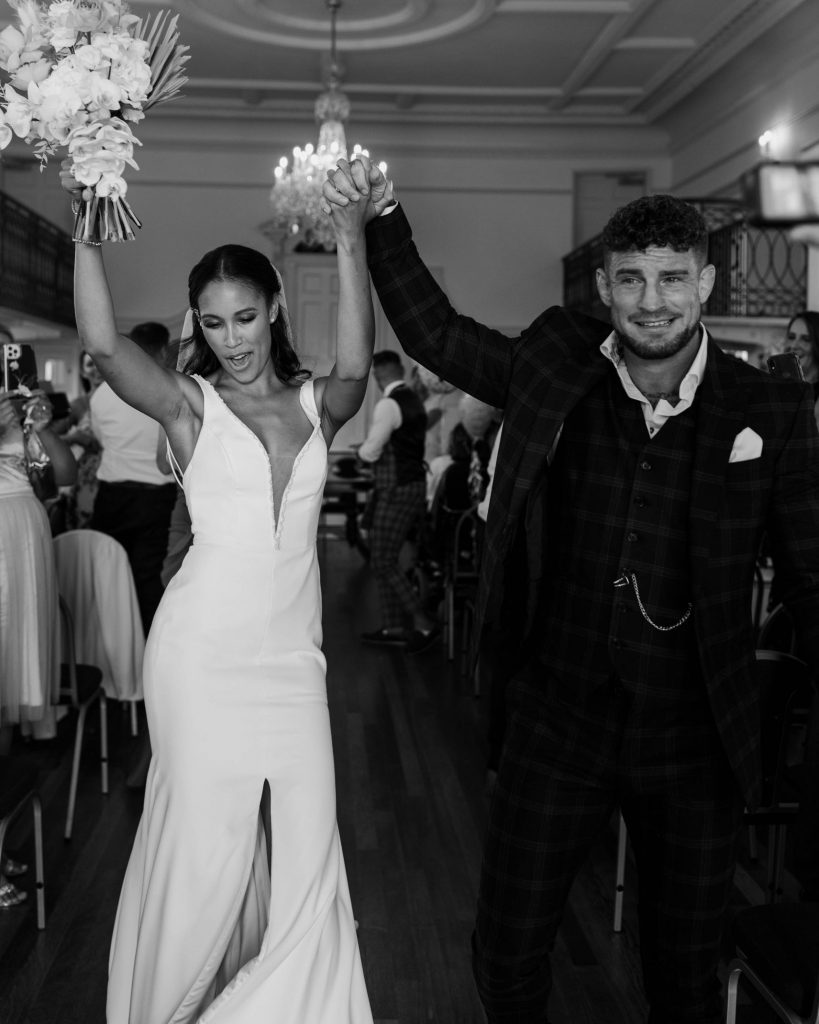 A triumphant fist pump for newlyweds Madison and Justin as they walk back down the aisle as husband and wife