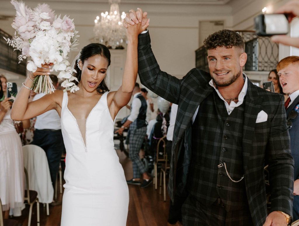 A triumphant fist pump for newlyweds Madison and Justin as they walk back down the aisle as husband and wife