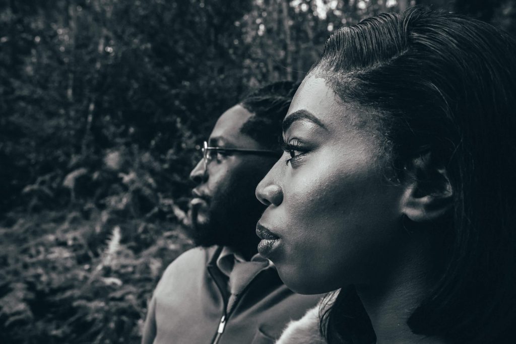 An artistic black and white wedding portrait image of a couple side on, looking in the same direction.