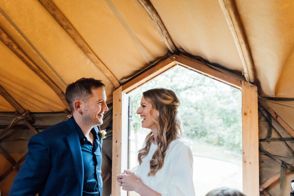 A bride and groom look at each other smiling, moments after they first see each other during their relaxed 'first look' during their non-traditional wedding celebrations.