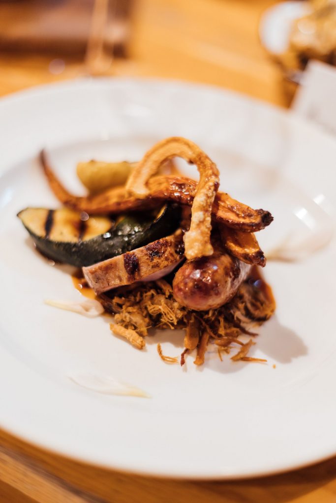 A beautifully presented meat dish on a white china plate prepared for wedding guests at a non-traditional wedding celebration at River Cottage.
