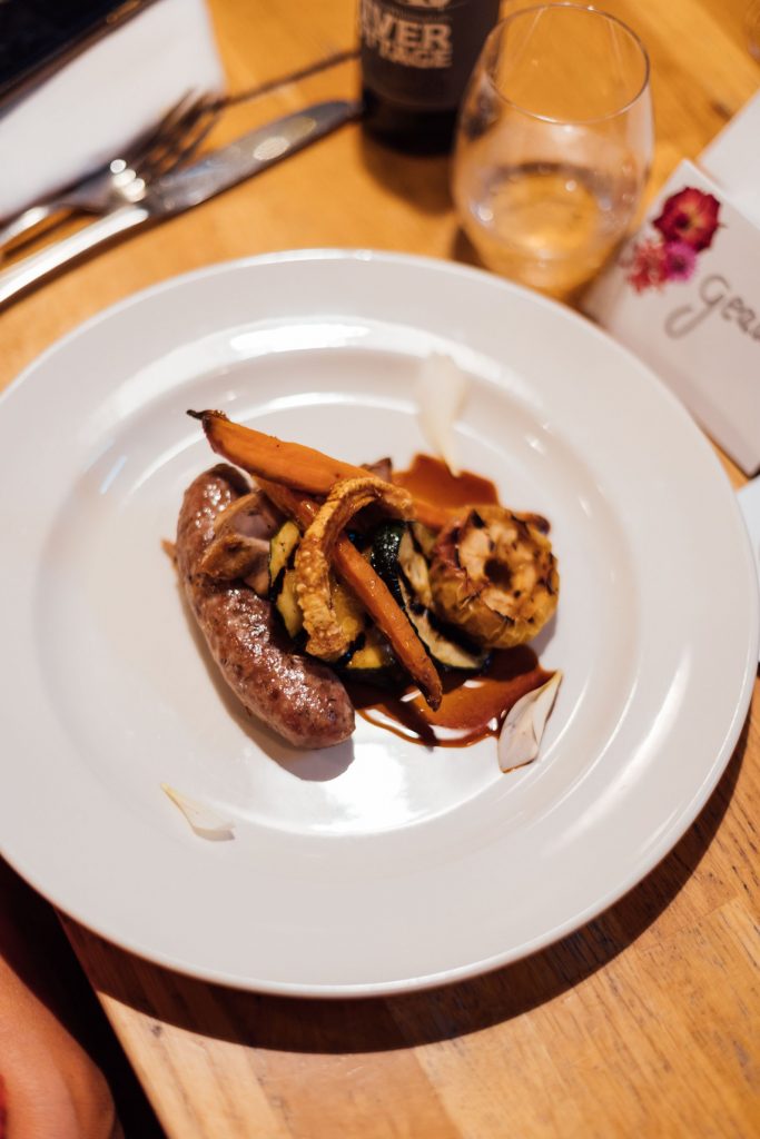 A beautifully presented meat dish on a white china plate prepared for wedding guests at a non-traditional wedding celebration at River Cottage.