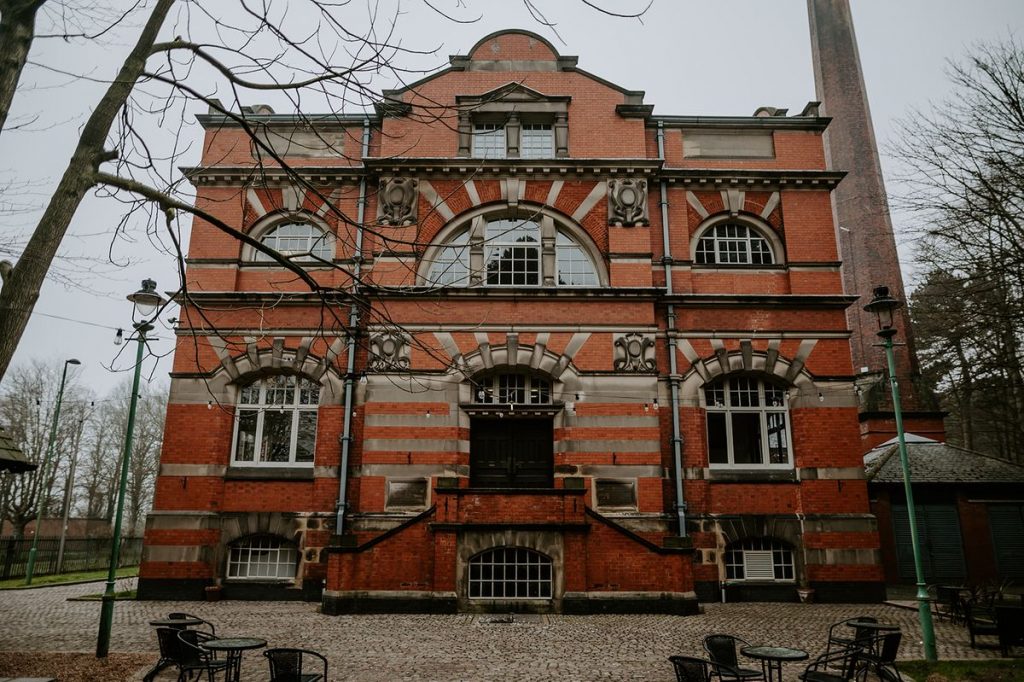 The distinct red brick buildig of The Pumping House wedding venue taken on a winter's day with a gloomy grey sky behind the large building.
