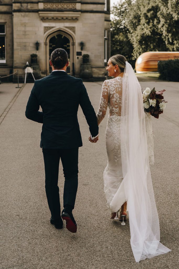 Beautiful bride in a long sleeved, high neck, embellished Yolancris wedding gown