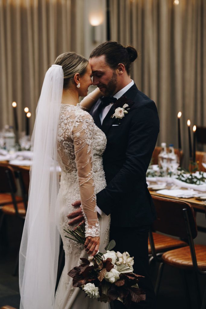 Beautiful bride in a long sleeved, high neck, embellished Yolancris wedding gown