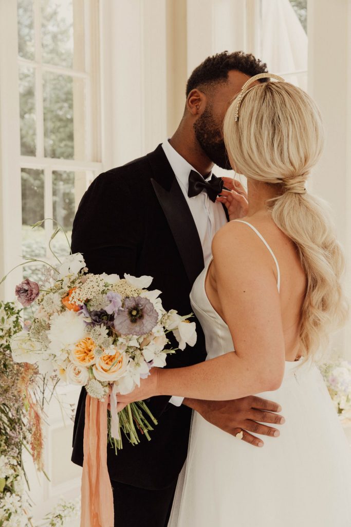 A low ponytail elevated with a sparkling Tilly Thomas Lux statement headpiece for a chic, modern wedding couple