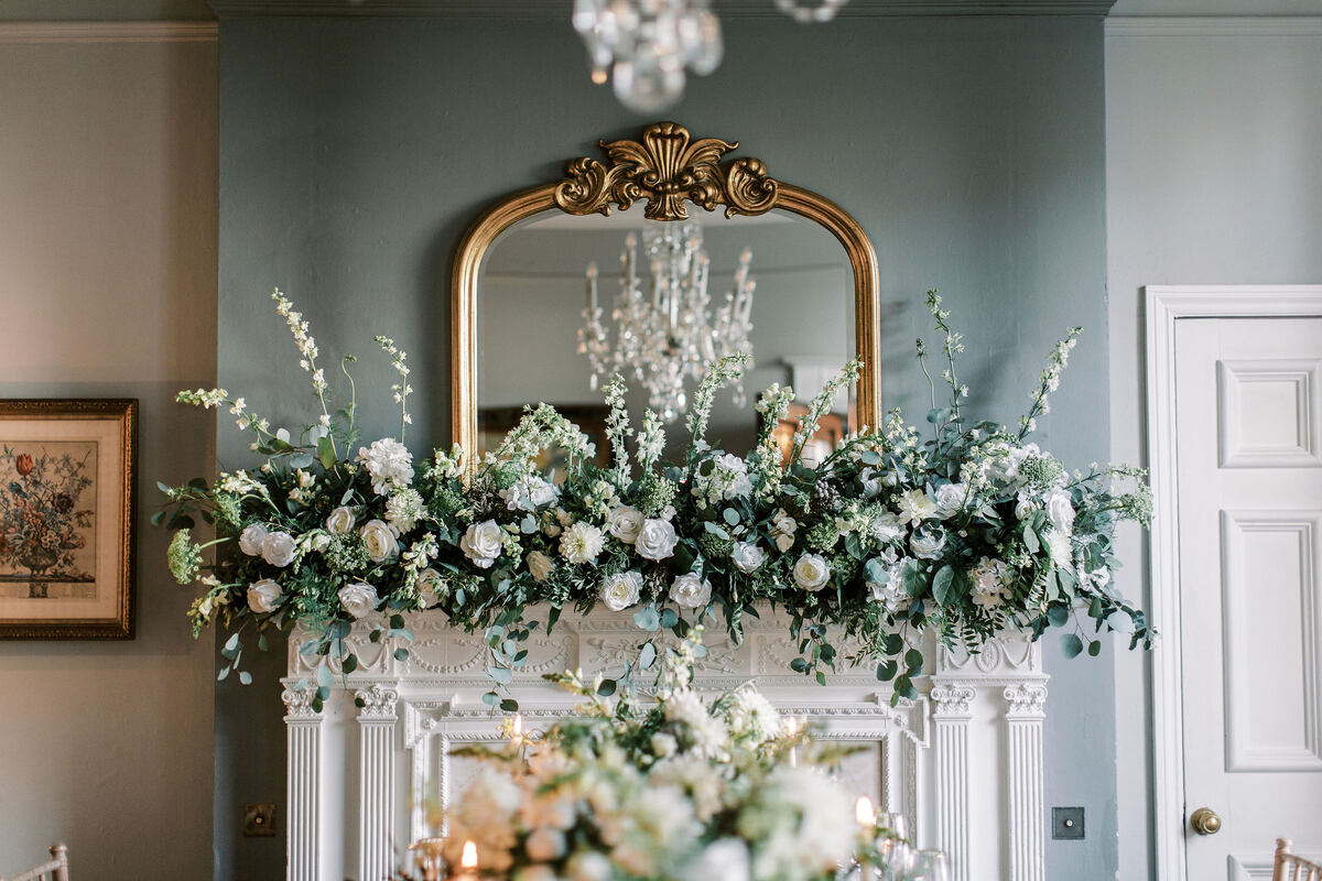 An elegant wedding tablescape with green + white florals and hints of gold