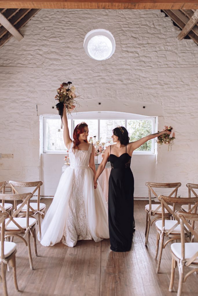 Newlyweds celebrating their marriage in the ceremony space at Gloucestershire's wedding venue Bredon Manor,