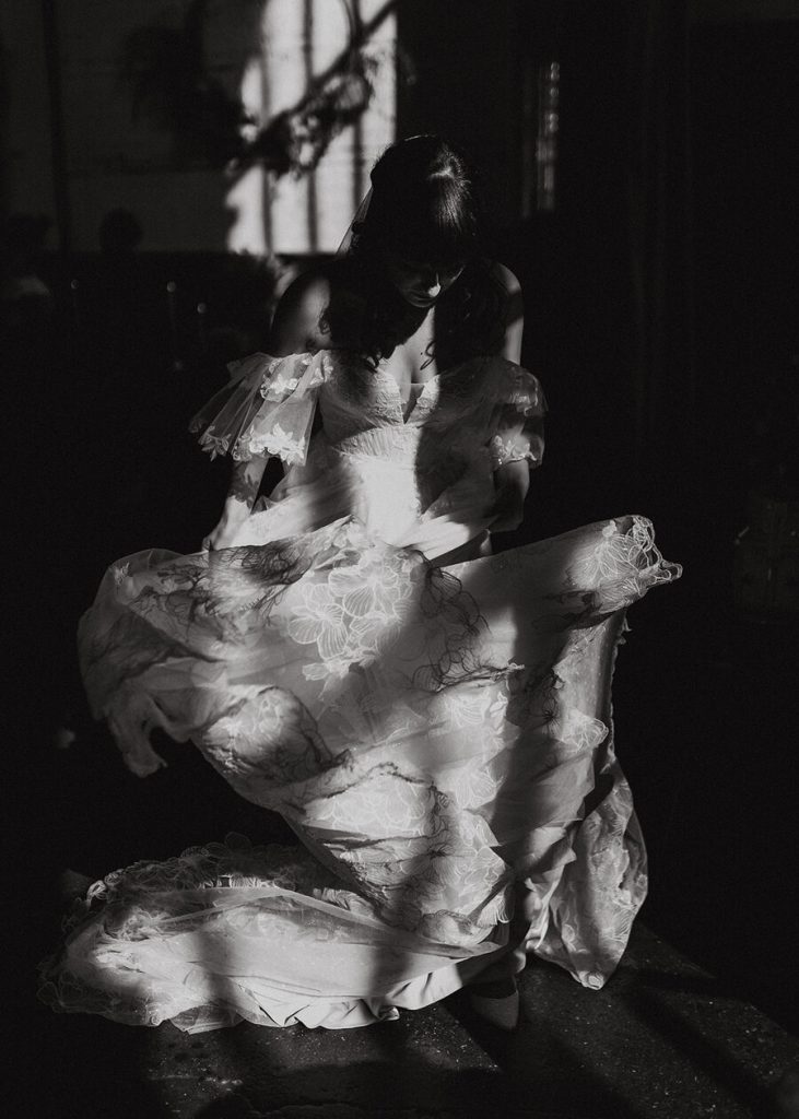 A bride twirls in her wedding dress, as pockets of beautiful light accentuate the intrictae detailing of the lace as she spins