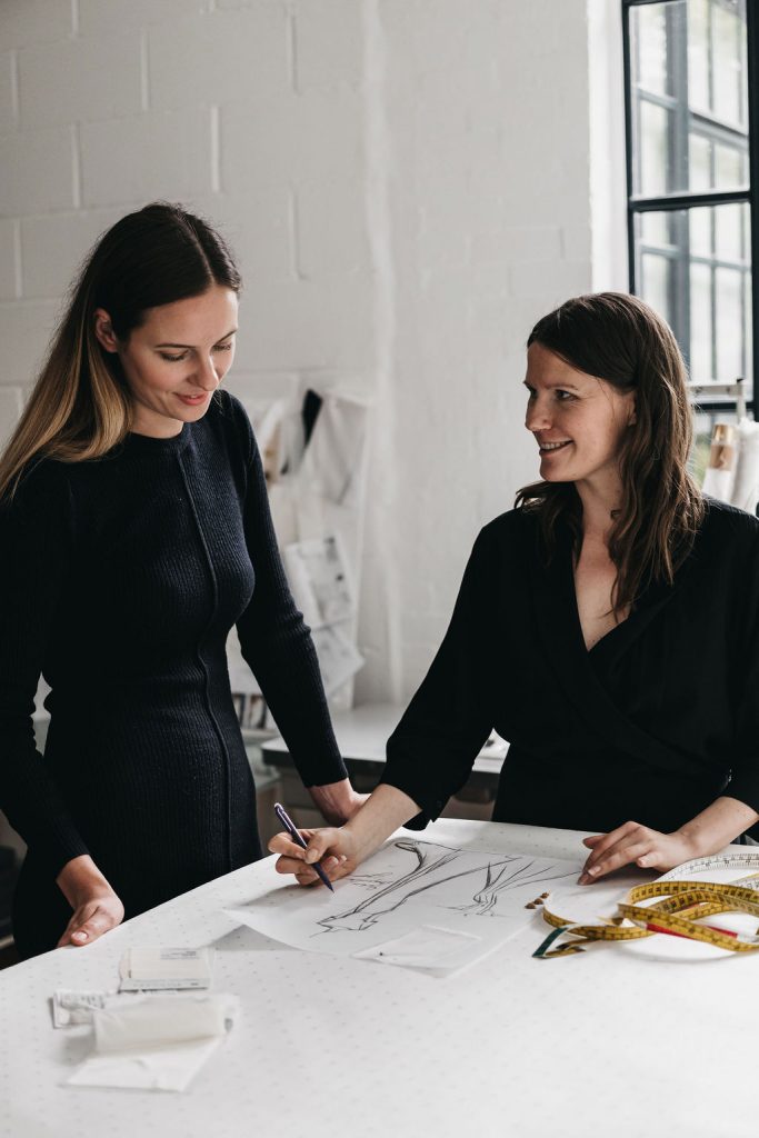 A bridal designer sketches mock ups of a wedding dress for her bride