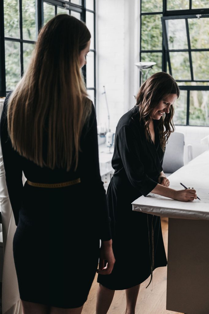 A bridal designer sketches mock ups of a wedding dress for her bride