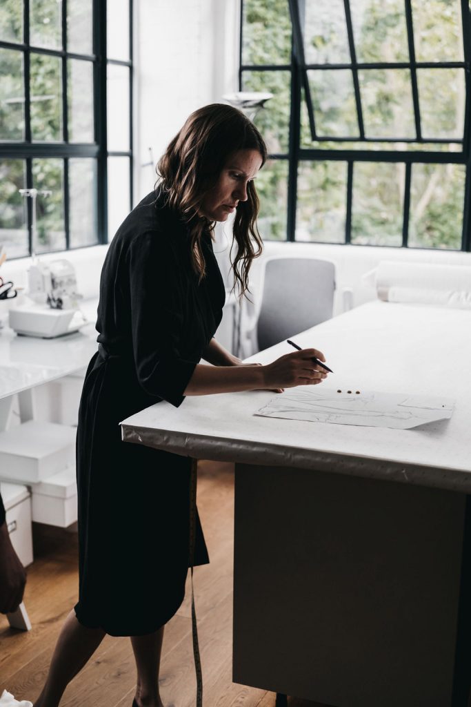 A bridal designer sketches mock ups of a wedding dress for her bride