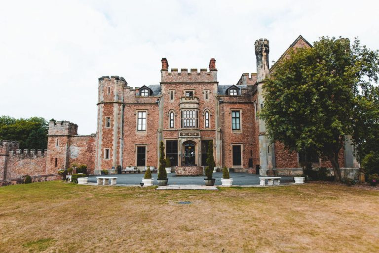 The entrance to Rowton Castle, a majestic, grand building with a large green garden space surrounding the imposing walls.