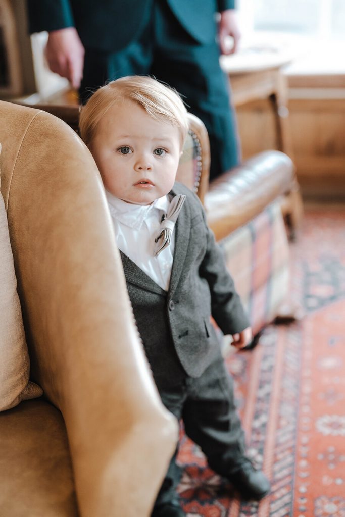 The littlest wedding guest looking adorable in an outfit that matches his Dad