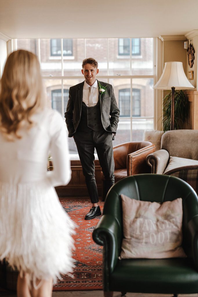 An intimate first look for a bride wearing a white Nadine Merabi skirt and a minimalist long sleeved body suit
