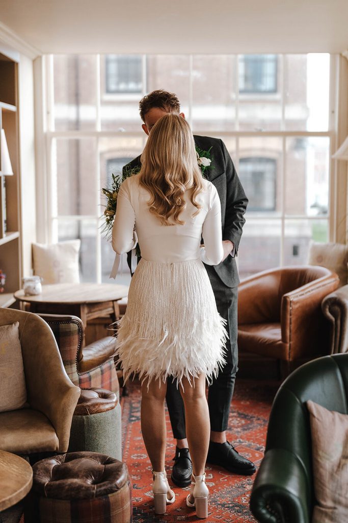 An intimate first look for a bride wearing a white Nadine Merabi skirt and a minimalist long sleeved body suit