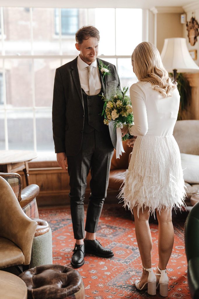 An intimate first look for a bride wearing a white Nadine Merabi skirt and a minimalist long sleeved body suit