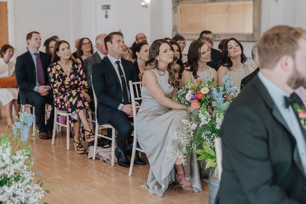 Guests enjoying the personalised readings at Annabel + Joe's Wasing Park wedding