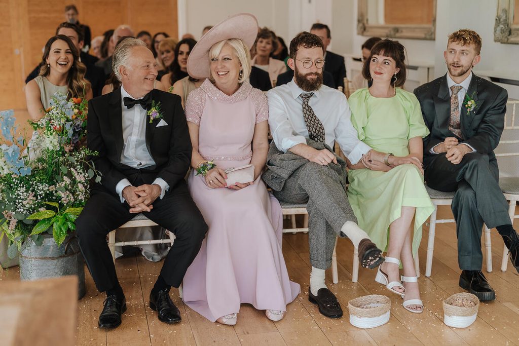 Guests enjoying the personalised readings at Annabel + Joe's Wasing Park wedding