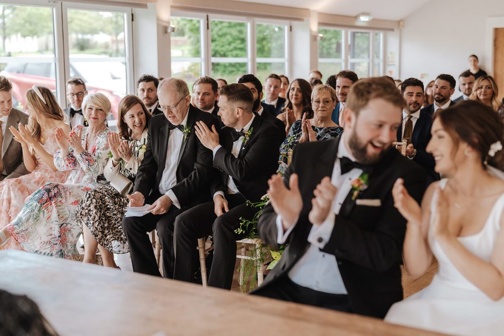 Guests enjoying the personalised readings at Annabel + Joe's Wasing Park wedding