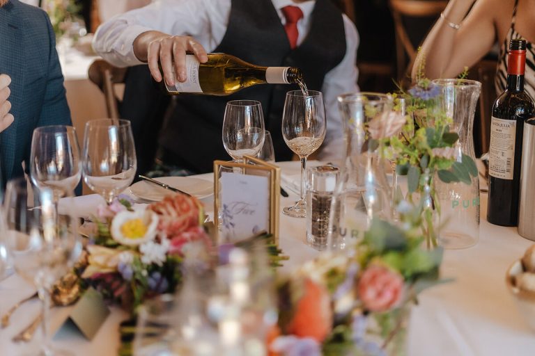 Guests enjoying feasting and wine during Annabel + Joe's wedding breakfast