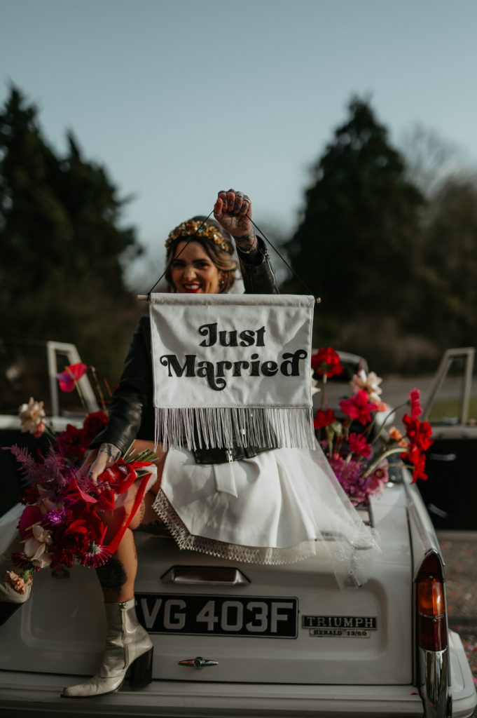 The ultimate wedding photo opportunity backdrop - a flower filled Classic triumph car