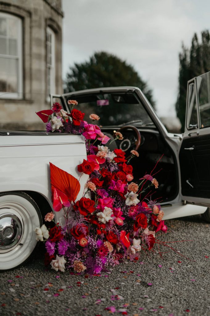 The ultimate wedding photo opportunity backdrop - a flower filled Classic triumph car