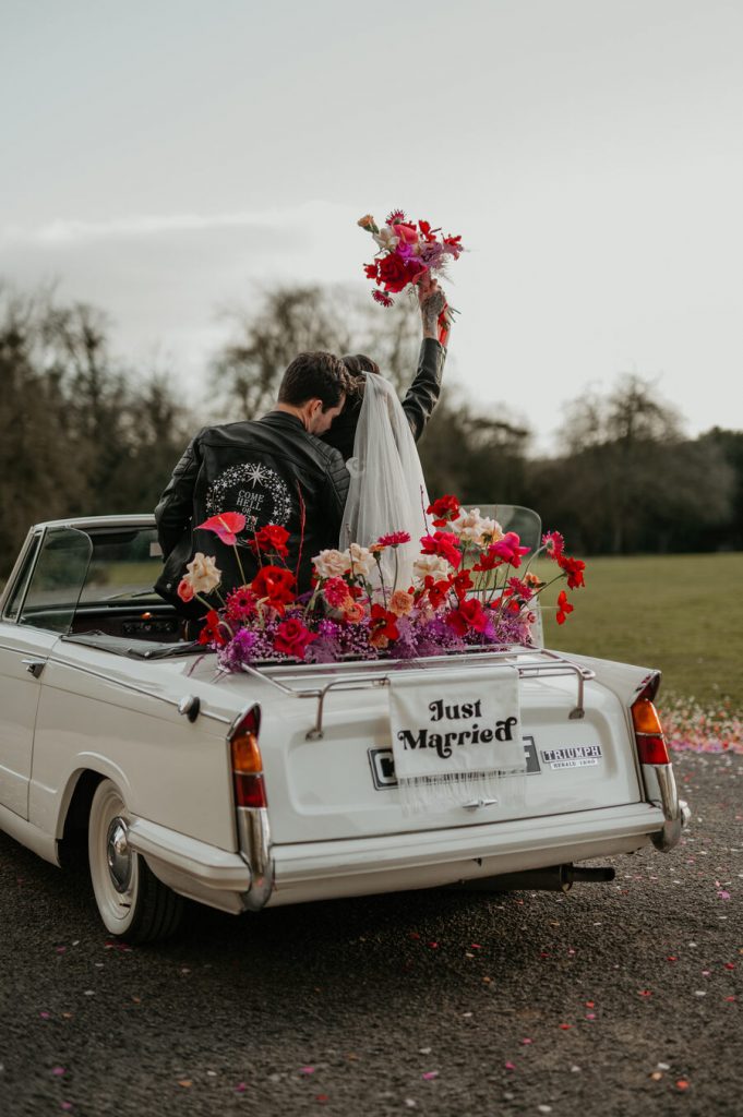 The ultimate wedding photo opportunity backdrop - a flower filled Classic triumph car
