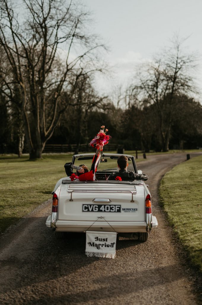 The ultimate wedding photo opportunity backdrop - a flower filled Classic triumph car