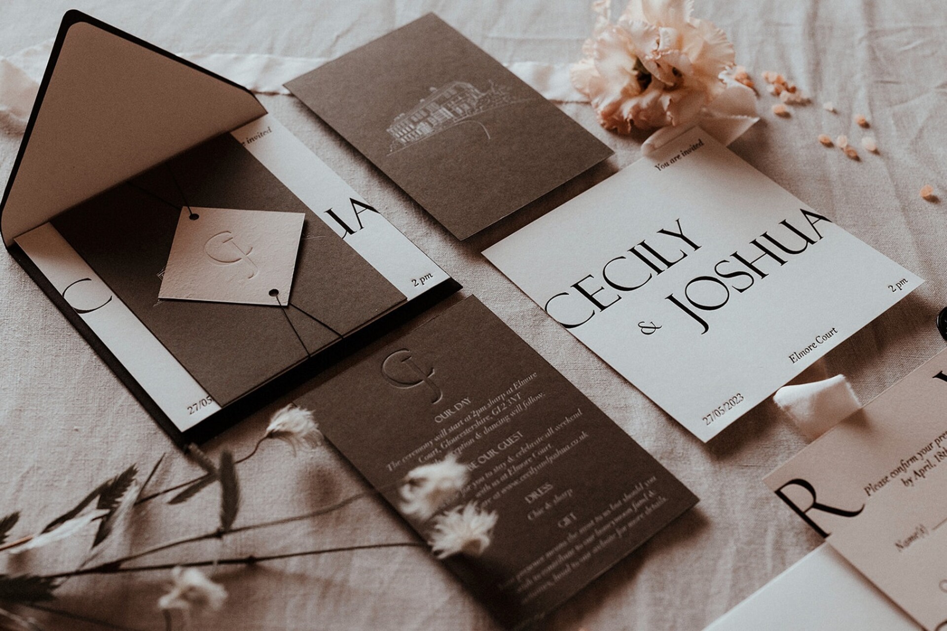 An elegant flat lay brown and white wedding invitation suite, embellished with fresh flowers for a modern, contemporary look.