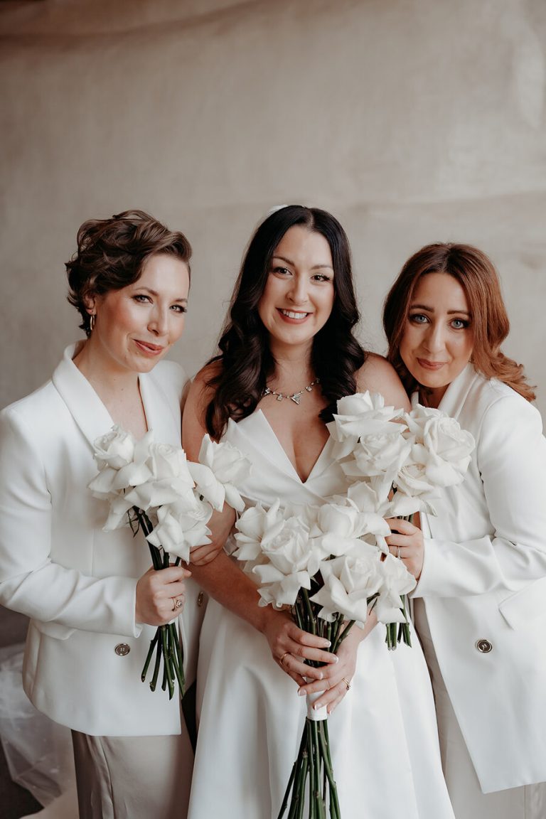Bride Rebecca, gorgeous in a Suzanne Neville gown stood in between her Maid of Honours who both wore white suits