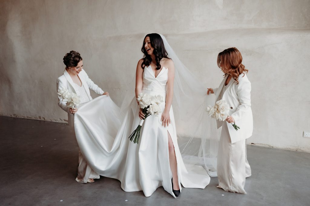 Bride Rebecca, gorgeous in a Suzanne Neville gown stood in between her Maid of Honours who both wore white suits